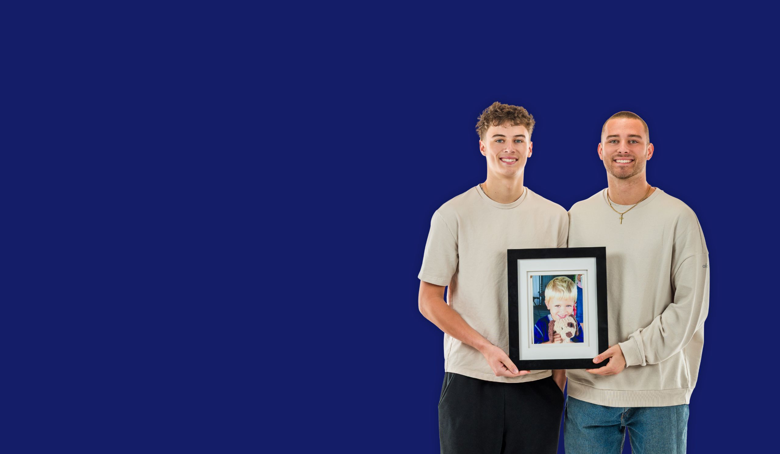 CJ and Tommy Carr holding a framed picture of their brother, Chad Carr.